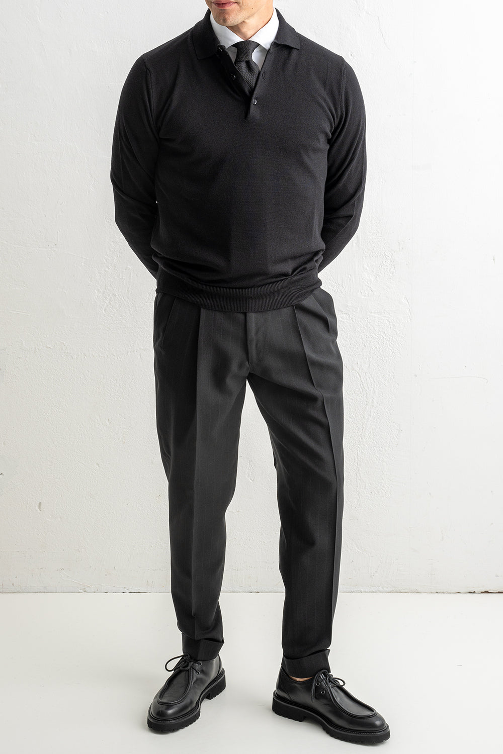 Merino Wool Polo Neck Black – ADVERB, helbild framifrån, händerna ihop