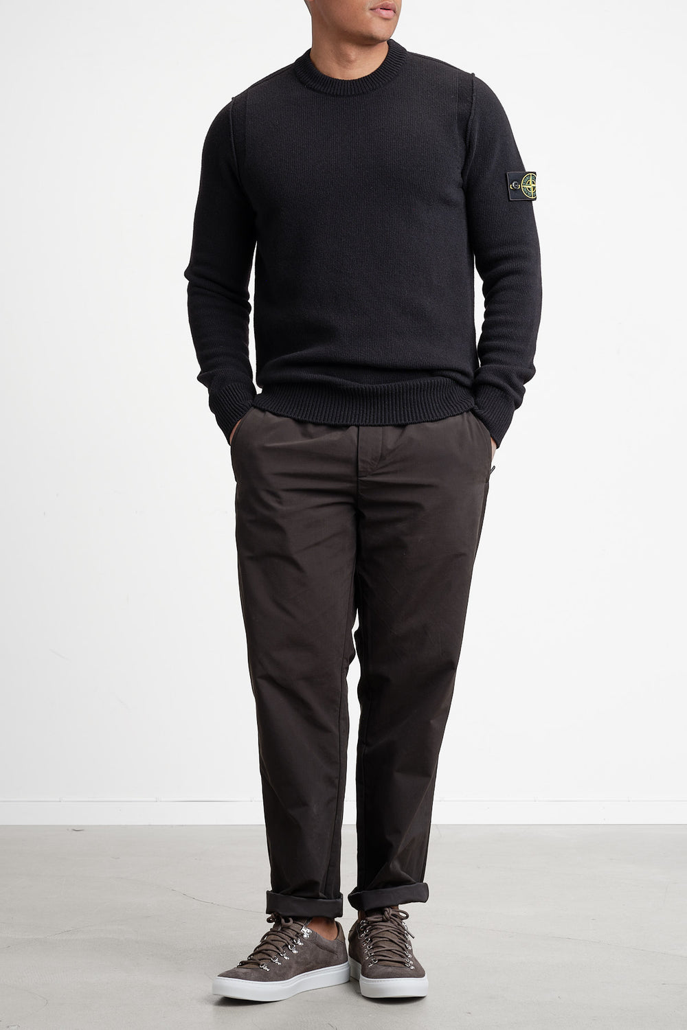 Lambswool Crew Neck Knit Black – STONE ISLAND, helbild på modell framifrån, händerna i fickorna